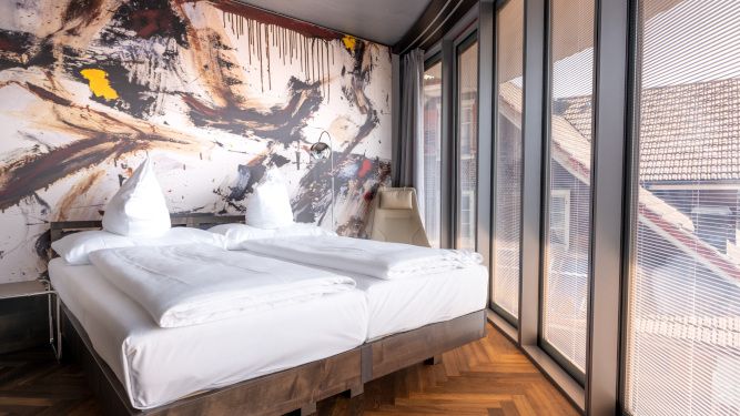 Hotelzimmer in Oberkirch Luzern, mit Doppelbett und Aussicht aus dem Fenster.